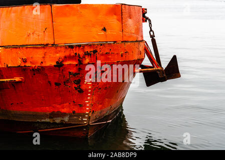 Close-up di prua di vecchio rosso ruggine nave ormeggiata in porto. Foto Stock