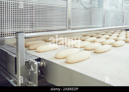 Materie il pane è rendere sull'apparecchiatura automatica di linea in panetteria. Foto Stock