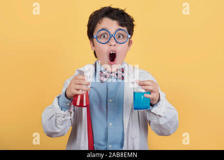 Bambino scienziato in laboratorio su sfondo giallo Foto Stock