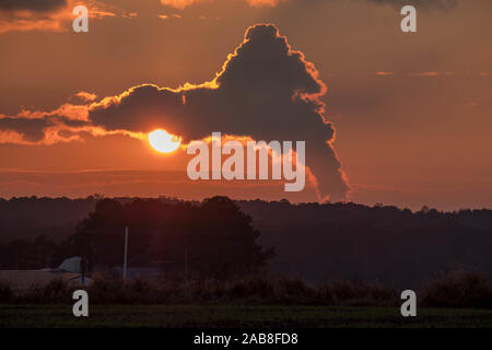 Un tramonto panoramico vista dal terreno coltivabile del ondeggianti vapore da un impianto ad energia nucleare come le nubi dal sole in Raleigh North Carolina. Foto Stock