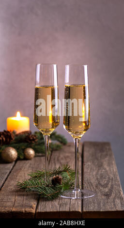 Due bicchieri di champagne su una tavola in legno rustico con decorazioni di vacanza Foto Stock