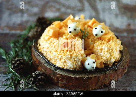 Anno Nuovo 2020 insalata. Mouse in insalata di formaggio con ananas e formaggio. Le decorazioni a forma di uovo topi. Foto Stock