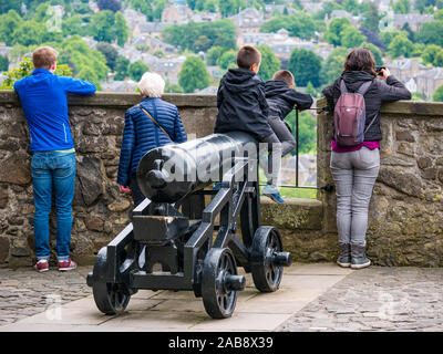 Twin boys giocando sulla vecchia pistola cannone e la gente che guarda fuori dal muro di castello, onorevoli Lookout, il Castello di Stirling, Scozia, Regno Unito Foto Stock