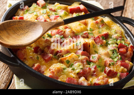 Tradizionale american strata con prosciutto, pane, cipolle, formaggio e uova vicino sul tavolo orizzontale. Foto Stock