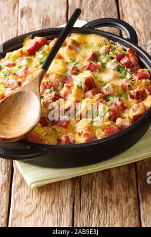 Una gustosa colazione Americana gli strati con prosciutto, pane, cipolle, formaggio e uova vicino sul piano verticale. Foto Stock