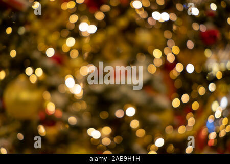 Holiday decorazioni, giocattoli, ghirlande su di un albero di Natale. Abstract sfondo sfocato con bokeh luci. Foto Stock