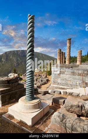 Il treppiede di Plataeans colonna e l'altare dell'Chiots con le colonne del tempio di Apollo dietro, Delphi sito archeologico, Delphi, Grecia Foto Stock