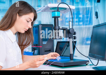 Lavoratore di sesso femminile nel controllo di resina LCD / DLP / SLA stampante 3D nel laboratorio di tecnologia Foto Stock