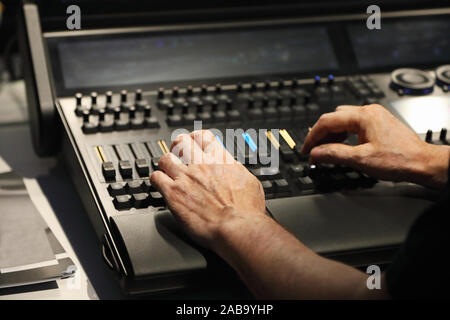 L'operatore lavora con compact illuminazione scenica della console di comando. Messa a fuoco selettiva. Foto Stock