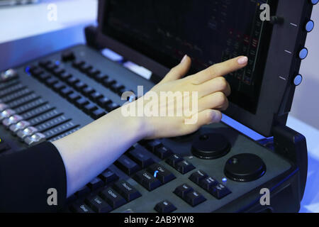 Operatore utilizzando il touch screen di controllo compatta professionale fase di illuminazione console. Messa a fuoco selettiva. Foto Stock