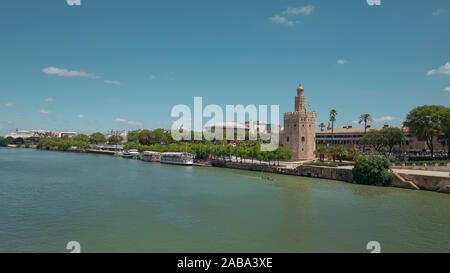 Vedute della città dal ponte Puente San Telmo oltre il fiume Guadalquivir verso la torre di avvistamento Torre del Oro, il Ponte di Triana e quartiere Seville Foto Stock