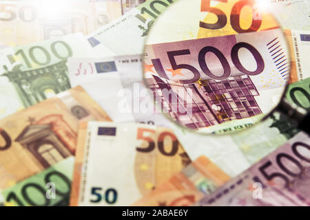 Lente di ingrandimento con le banconote in euro Foto Stock