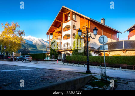 Bansko, Bulgaria autunno street e neve catena montuosa del Pirin, case e alberi colorati Foto Stock