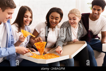 Happy amici celebrando riunioni, mangiare pizza calda Foto Stock