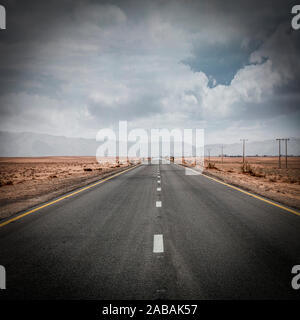 Strada solitaria in mezzo al wadi rum desert in Giordania. nessuno in giro. Concetto di avventura e di libertà. Foto Stock