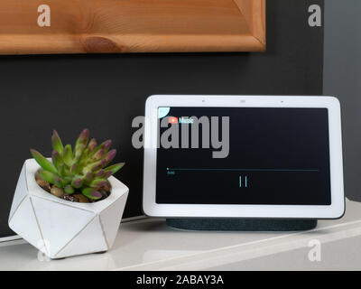 Nov 2019, UK - Google Nest mozzo sul caminetto in soggiorno impostando la riproduzione di musica di youtube Foto Stock