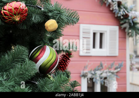 Alberi di Natale e il giocattolo casa su una strada d'inverno. Nuovo Anno decorazioni in una città, la magia della vacanza Foto Stock