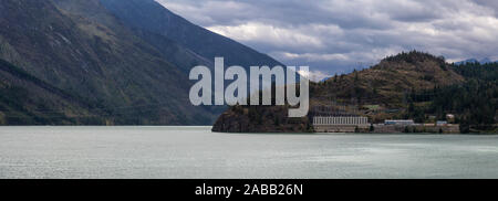 Vista panoramica di una stazione elettrica dal Seton lago durante un nuvoloso giorno d'estate. Preso in Shalalth, nei pressi di Lillooet, British Columbia, Canada. Foto Stock