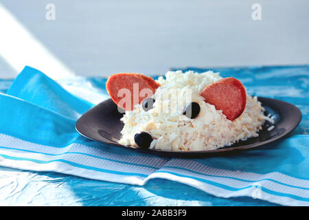 Nuovo anno 2020 - anno del ratto bianco. Carino insalata - bianco sul ratto il formaggio da uova, salsiccia e olive su un asciugamano blu Foto Stock