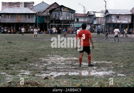 Gli uomini giocano a calcio (calcio) in il peruviano bidonville Belen, vicino a Iquitos, Perù. Foto Stock