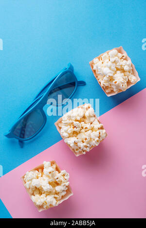 Popcorn con gli occhiali 3D su sfondo blu Foto Stock