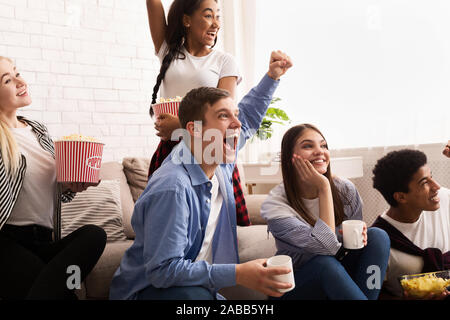 Gli adolescenti emozionale guardando la partita di calcio in tv e rasserenanti Foto Stock