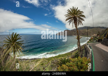 Vista dell'isola di Tenerife da Santa Catalina beach. Enormi pilastri di calcestruzzo per gru e le rovine del vecchio porto Hermigua in background. La G Foto Stock