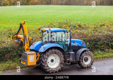 Azienda contraente agricoltore alla guida di un trattore taglio di siepi durante l'autunno con un McConnel tagliasiepi Foto Stock