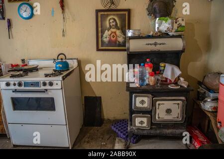 Cucina, stufa a legna, orologio da parete, piatti, pentole, casella di religiosi, Gesù Cristo, e gli interni della casa del cowboy Ruben Arviuzu Reyes, nella città di Pilares de Nacozari. Ruben si prende cura delle vecchie costruzioni della città fantasma che è anche una città turistica o abbandonato la città mineraria. Pilares, è una città nel comune di Nacozari de García, Sonora, Messico, nella zona superiore della Sierra Madre Occidental. Dal 1960 è noto come una città fantasma a causa della sua spopolamento nel 1920s, a causa della chiusura e di eliminazione delle società minerarie che sono state qui. © © (© Foto: LuisGutierrez NorteP Foto Stock