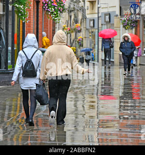 Scena di strada di piovere su persone in condizioni di bagnato centro città soli pedoni shoppers street zona nella riflessione di pioggia & riflessioni Durham Regno Unito Inghilterra Foto Stock