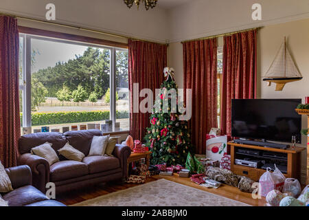 Il giorno di Natale presso la nostra casa con presenta sotto un albero in attesa per i bambini Foto Stock