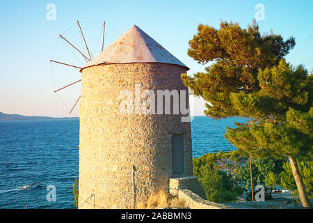 Bellissima vista sul vecchio mulino a vento e mare sull isola Hydra, Grecia dell'orario del tramonto. La migliore destinazione di viaggio in Europa. Selezione tivo focus. Foto Stock