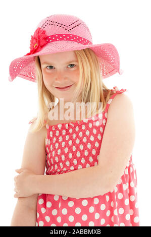 Close up di sorridere giovane e bella ragazza bionda che indossa big pink floppy hat e una polka dot dress. Isolato su bianco di sfondo per studio Foto Stock