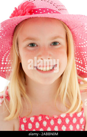 Close up della giovane e bella ragazza bionda con un grande sorriso indossando un big pink floppy hat e guardare direttamente la fotocamera. Isolato su bianco studio ba Foto Stock