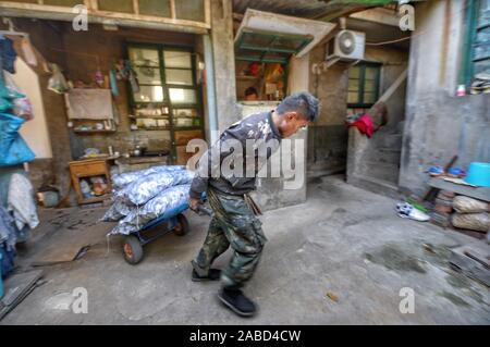 Un estrattore di carbone funziona per spostare sacchi di carbone, in totale dieci tonnellate ogni giorno, le case dei residenti che vivono in città vecchia di Jinan City, est della Cina di Shandong p Foto Stock