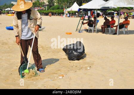 Una persona che preleva i rifiuti lasciati dai turisti vicino alla spiaggia di Yalong Bay di Sanya city, a sud della Cina di Hainan provincia, 4 ottobre 2019. Foto Stock