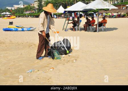 Una persona che preleva i rifiuti lasciati dai turisti vicino alla spiaggia di Yalong Bay di Sanya city, a sud della Cina di Hainan provincia, 4 ottobre 2019. Foto Stock