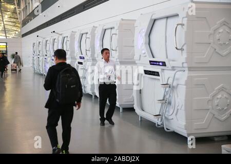 Un personale cammina verso una capsula hotel a Yinchuan Hedong Aeroporto Internazionale nella città di Yinchuan, a nord-ovest della Cina di Ningxia, 23 ottobre 2019. Foto Stock