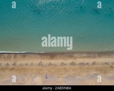 Top down vista aerea di un uomo disteso sulla spiaggia sabbiosa. Foto Stock