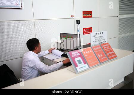 Un personale lavora presso il contatore della capsula hotel a Yinchuan Hedong Aeroporto Internazionale nella città di Yinchuan, a nord-ovest della Cina di Ningxia, 23 Foto Stock