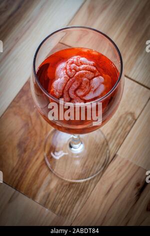 Cervello umano nel vino rosso di imbibizione di vetro per alcolismo tossicodipendenze concept Foto Stock