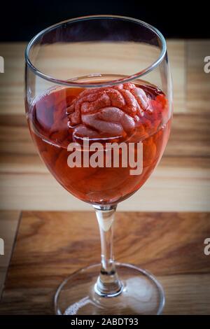 Cervello umano nel vino rosso di imbibizione di vetro per alcolismo tossicodipendenze concept Foto Stock