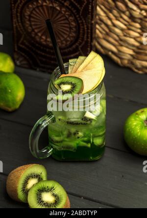 Kiwi cocktail guarnito con kiwi e fette di mela Foto Stock