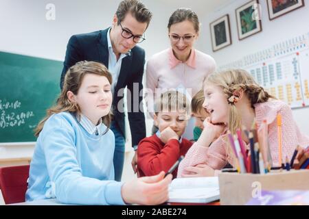 Lavoro di gruppo sessione a scuola con gli insegnanti e gli alunni Foto Stock