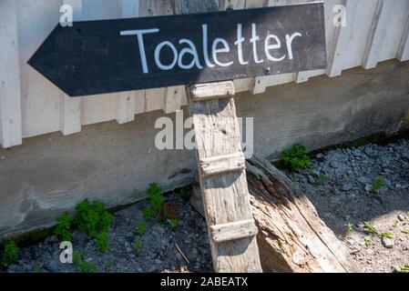 Koster, Svezia. 12 Luglio, 2019. Un cartello per un WC si trova di fronte a una casa sull'isola Koster. Credito: Stephan Schulz/dpa-Zentralbild/ZB/dpa/Alamy Live News Foto Stock