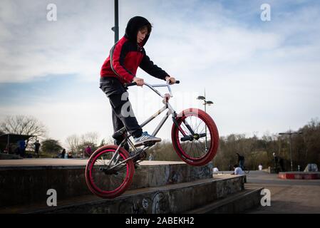 Un rider BMX presso il locale skate park a Stoke on Trent, Stoke Plaza, usa cemento rampe e ciotole per fare pratica e passare da, pilota professionista Foto Stock