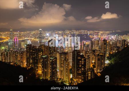 Vista notturna del porto di Victoria con molti grattacieli sulla sommità del Victoria Peak nella regione amministrativa speciale di Hong Kong, Cina Foto Stock