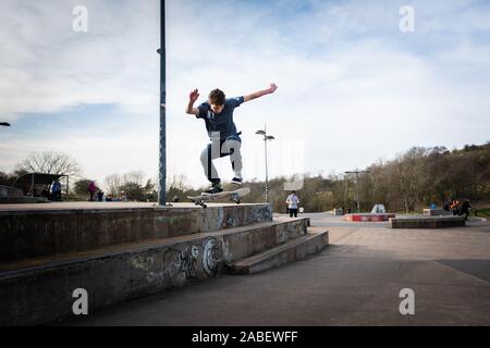 Skateboarders ollie off alta passi sul calcestruzzo al di sotto, avventura pericolosa, sport estremi, professional skaters, Skateboard Foto Stock