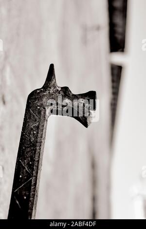 Una decorazione a testa di cavallo rinascimentale di dettaglio del ferro battuto per legare i cavalli all'architettura toscana facciate di San Quirico d'Orcia Toscana B/W Foto Stock