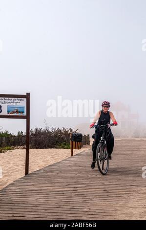 Cicli di donna sulla Eurovelo 1 costa atlantica rotta vicino Porto, Portogallo. Costa dell'Oceano Atlantico sulla sinistra Foto Stock